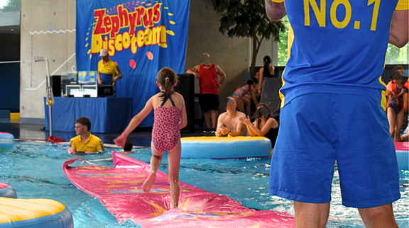 KidsClub Sommerfest: Ein Mädchen im pinken Badeanzug auf einem Aquatrack